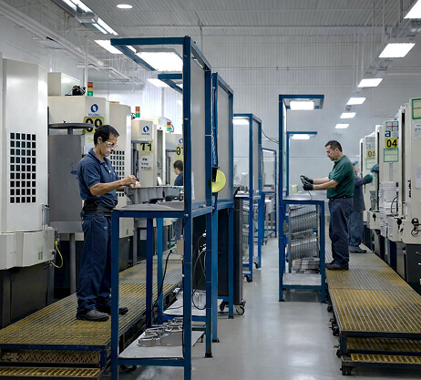 Technicians at die casting machine control stations on the plant floor